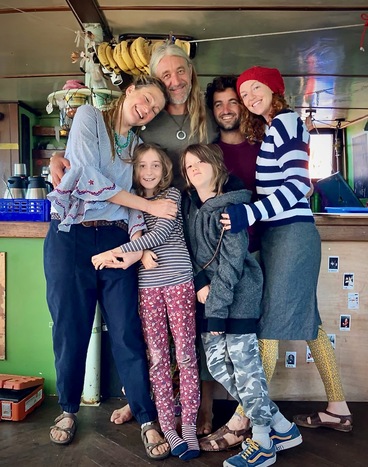 Smiling group photo of Maruska Polakova, Caption Clemens Gabriel Oestreich, Erick, Sage Livingston, Rhian Livingston and Chloe Livingston in the galley of Infinity ship.